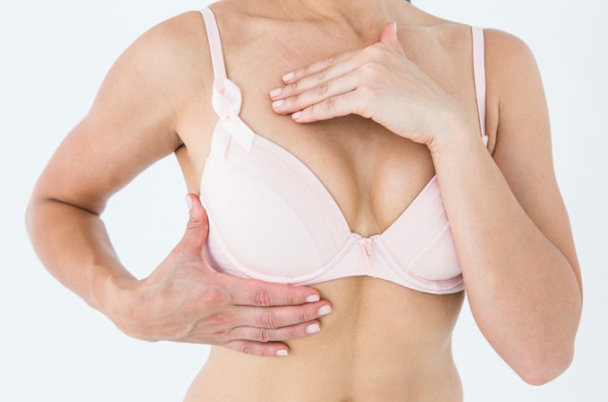 Image of a woman wearing a bra and examining her breast size