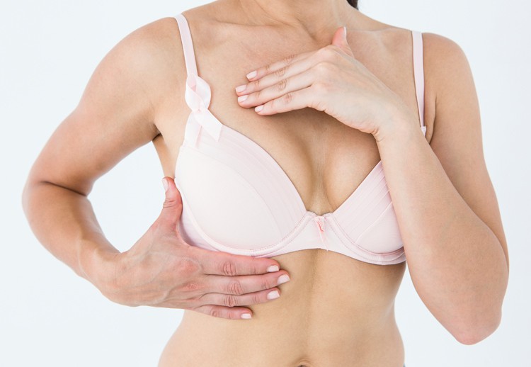 Image of a woman wearing a bra and examining her breast size